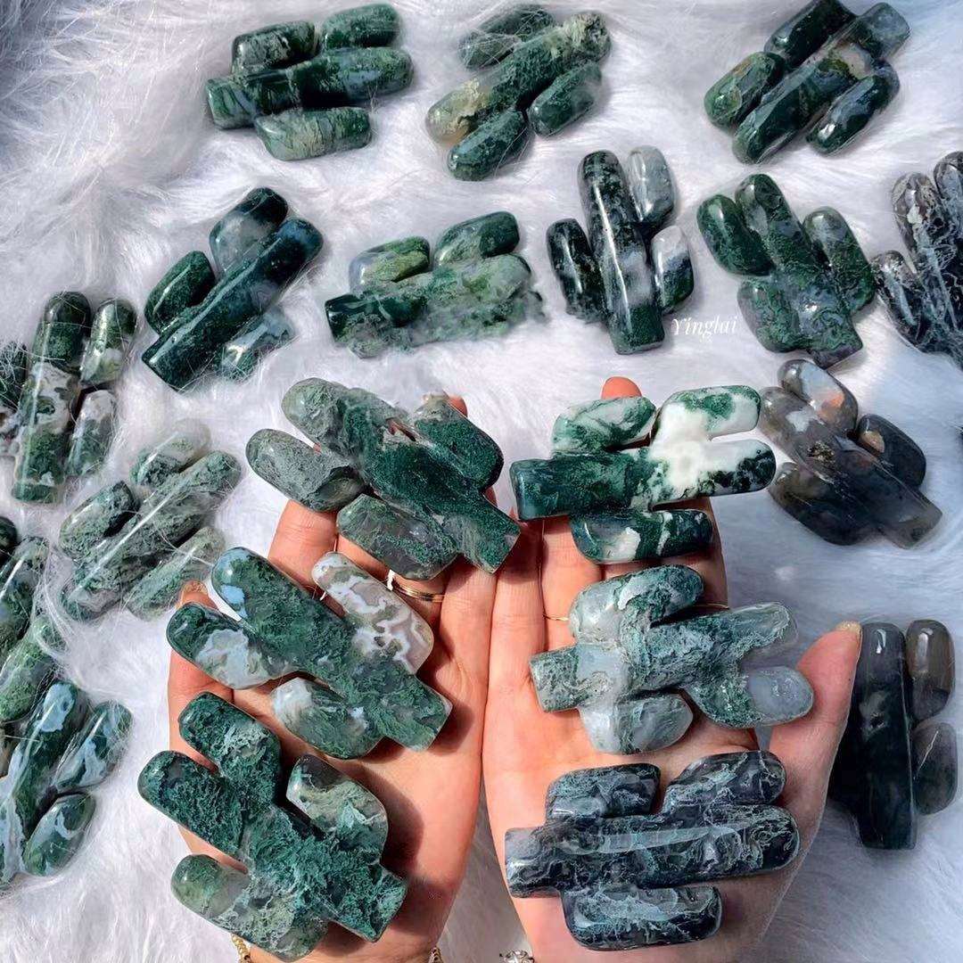 Photo of woman holding cactus shaped moss agate crystals